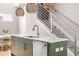 Modern kitchen featuring a green island, stainless steel appliances, and an open staircase at 2733 W 28Th Ave # 6, Denver, CO 80211