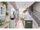 Bright kitchen with stainless steel appliances, white cabinets, a green island and woven pendant lights at 2733 W 28Th Ave # 6, Denver, CO 80211
