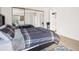 Well-lit bedroom with mirrored closet doors and a glimpse into the en-suite bathroom at 6755 S Ivy St # A7, Centennial, CO 80112
