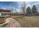 Expansive backyard featuring a pergola-covered deck, mature trees, hot tub, and a well-maintained lawn at 9256 W Euclid Ave, Littleton, CO 80123