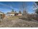 Spacious backyard featuring a deck with pergola, manicured brick flower beds, and mature trees for added privacy at 9256 W Euclid Ave, Littleton, CO 80123