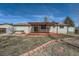 The backyard features a large deck with a pergola and a hot tub with a manicured brick flower bed at 9256 W Euclid Ave, Littleton, CO 80123