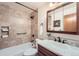 Updated bathroom with tub, tiled walls, and decorative fixtures at 9256 W Euclid Ave, Littleton, CO 80123