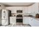 Modern kitchen with stainless steel appliances, white cabinets, and ample counter space at 9256 W Euclid Ave, Littleton, CO 80123