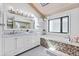 Stylish bathroom with a double vanity, soaking tub, and modern fixtures at 347 S White Tail Dr, Franktown, CO 80116