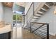 Bright foyer with modern staircase, chandelier, and natural light streaming through the glass front door for an inviting entrance at 347 S White Tail Dr, Franktown, CO 80116