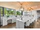 Bright kitchen featuring a large island with seating, modern white cabinets, and a picturesque outdoor view at 347 S White Tail Dr, Franktown, CO 80116