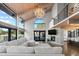 Open living room with vaulted ceilings, large windows, stone fireplace, and balcony access, ideal for modern living and entertaining at 347 S White Tail Dr, Franktown, CO 80116
