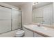 Bright bathroom with a shower and tub combination with glass doors and a large mirror at 13535 W 62Nd Ln, Arvada, CO 80004