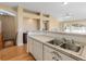 Bright open-concept eat-in kitchen offers a breakfast bar with an adjoining staircase and living room at 13535 W 62Nd Ln, Arvada, CO 80004