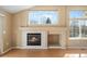 Inviting living room features a fireplace, tile surround, mantle, and large windows providing natural light at 13535 W 62Nd Ln, Arvada, CO 80004