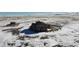 Aerial view of a house on a snowy lot, with a small shed in the background at 11100 Haskell Creek Rd, Larkspur, CO 80118