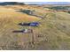 Aerial view of gray home on a sloped grassy lot at 11100 Haskell Creek Rd, Larkspur, CO 80118
