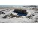 Aerial view of a house on a snowy lot with a fenced area at 11100 Haskell Creek Rd, Larkspur, CO 80118