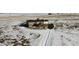 Aerial view of a ranch style home on a snowy landscape with a detached garage and a long driveway at 11100 Haskell Creek Rd, Larkspur, CO 80118