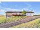 Back of house with deck and two car garage on a sloped lot with grass at 11100 Haskell Creek Rd, Larkspur, CO 80118