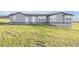 Gray home with a daylight basement, white trim, and gravel beds at the foundation at 11100 Haskell Creek Rd, Larkspur, CO 80118