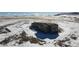 Drone shot highlighting a single Gathering home with gray siding, double pane windows, and black roof surrounded by snow at 11100 Haskell Creek Rd, Larkspur, CO 80118