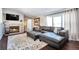 Cozy living room with fireplace, large leather couch with ottomans, and large windows at 11100 Haskell Creek Rd, Larkspur, CO 80118