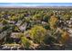 Aerial view of a neighborhood with lush tree coverage, showcasing rooftops and distant mountain views at 4157 Perry St, Denver, CO 80212