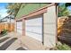 Two-car garage with white doors and green trim, providing ample parking and storage space at 4157 Perry St, Denver, CO 80212