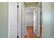 Hallway with wood floors, coat closet, and view into bedroom at 4157 Perry St, Denver, CO 80212