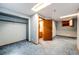 Basement area with blue carpet, closet, and a view into an attached bathroom at 12842 Bellaire St, Thornton, CO 80241