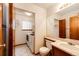 Cozy bathroom with laundry, featuring tile floors, a single vanity, and a combined washer and dryer unit at 12842 Bellaire St, Thornton, CO 80241