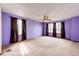 Large bedroom with three windows, neutral carpet, and a ceiling fan at 12842 Bellaire St, Thornton, CO 80241