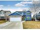 Beautiful two-story house with a well-maintained front lawn, blue siding, and brick detail at 12842 Bellaire St, Thornton, CO 80241