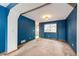 Open living room with bright blue walls, a large window with views, and neutral carpet flooring at 12842 Bellaire St, Thornton, CO 80241