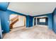 Open living room with bright blue walls, a stairway to the second floor, and neutral carpet flooring at 12842 Bellaire St, Thornton, CO 80241