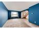 Open living room with bright blue walls, a stairway to the second floor, and neutral carpet flooring at 12842 Bellaire St, Thornton, CO 80241