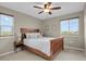 Bright bedroom with two windows, ceiling fan, and wood frame bed with white bedding at 30 S Ider Way, Aurora, CO 80018