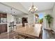 Dining room with a chandelier, hardwood floors, and an open layout to the kitchen and outdoor patio at 30 S Ider Way, Aurora, CO 80018