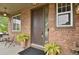 Inviting front entry featuring a stylish brown door, brick facade, and potted plants at 30 S Ider Way, Aurora, CO 80018