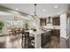 Open kitchen boasts a large island, stainless appliances, dark wood cabinets, and adjacent dining area at 30 S Ider Way, Aurora, CO 80018