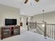 Spacious loft area with railing, ceiling fan, and media center at 30 S Ider Way, Aurora, CO 80018