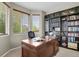 Home office features a large desk, built-in bookshelves, and a bay window at 30 S Ider Way, Aurora, CO 80018