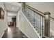 Staircase features carpeted steps, decorative wrought iron railings, and wood banister at 30 S Ider Way, Aurora, CO 80018