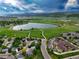 Scenic aerial view of a community featuring a serene lake, green spaces, and mountain views under a beautiful blue sky at 5836 S Vivian Way, Littleton, CO 80127