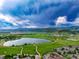 Enjoy community amenities, including a lake and greenbelt, plus mountain views from this serene community under a blue sky at 5836 S Vivian Way, Littleton, CO 80127