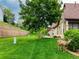 Backyard view of a landscaped lawn with a retaining wall, mature tree, and a deer grazing near the side of the home at 5836 S Vivian Way, Littleton, CO 80127