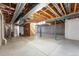 Large unfinished basement with concrete floor and exposed beams ready to be finished at 5836 S Vivian Way, Littleton, CO 80127