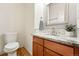 A well-lit bathroom with granite countertops, mosaic backsplash and tile accents creates a modern, clean design at 5836 S Vivian Way, Littleton, CO 80127