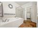 Relaxing bathroom featuring a soaking tub, tiled floor, and an adjoining walk-in closet at 5836 S Vivian Way, Littleton, CO 80127
