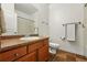 Full bathroom with wood vanity, white sink, tiled floors, and chrome fixtures at 5836 S Vivian Way, Littleton, CO 80127
