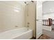 Bright bathroom with a white tiled shower over tub and neutral walls at 5836 S Vivian Way, Littleton, CO 80127