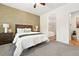 This spacious bedroom features an en suite bathroom, textured accent wall, carpet, and natural light at 5836 S Vivian Way, Littleton, CO 80127