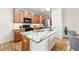 A spacious kitchen featuring stainless steel appliances, an island with granite countertops, and hardwood floors at 5836 S Vivian Way, Littleton, CO 80127